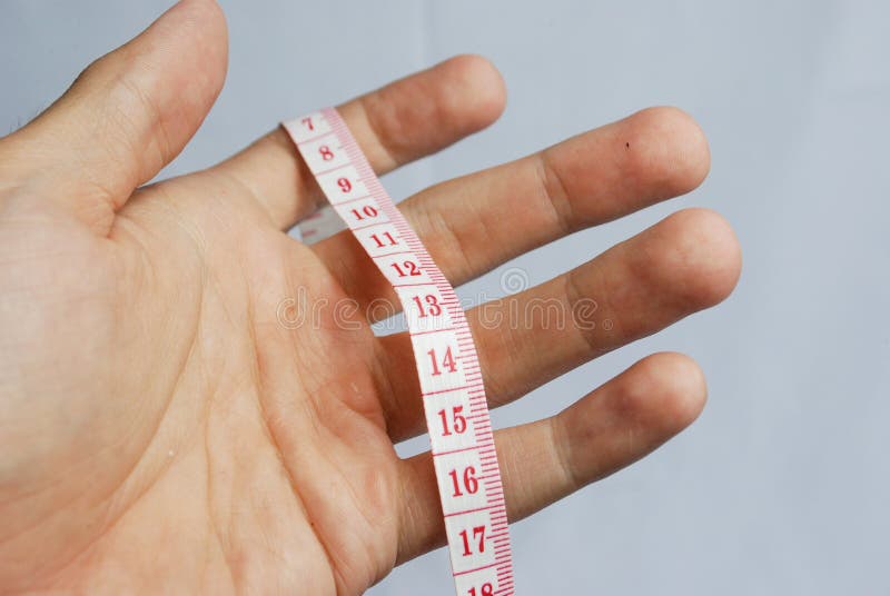 Man hand hold measuring lint with red numbers on white background