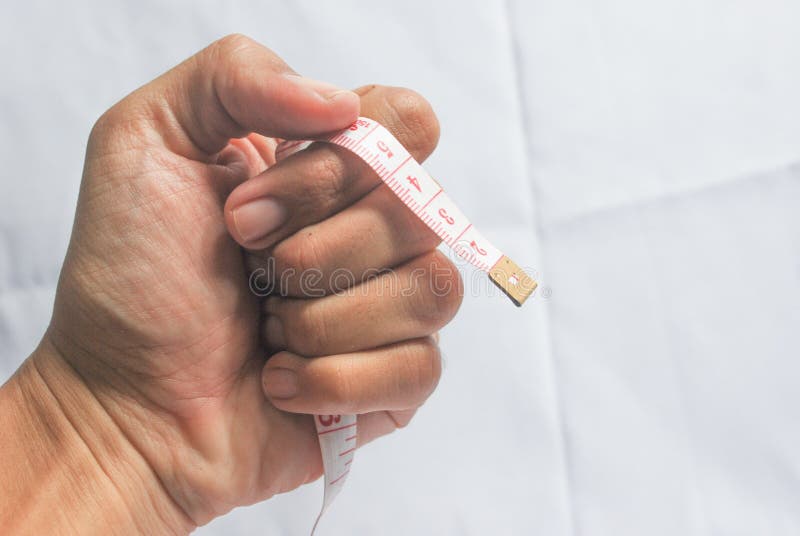 Man hand hold measuring lint with red numbers on white background