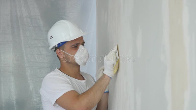 Man Hand Sanding Plaster Wall, close up