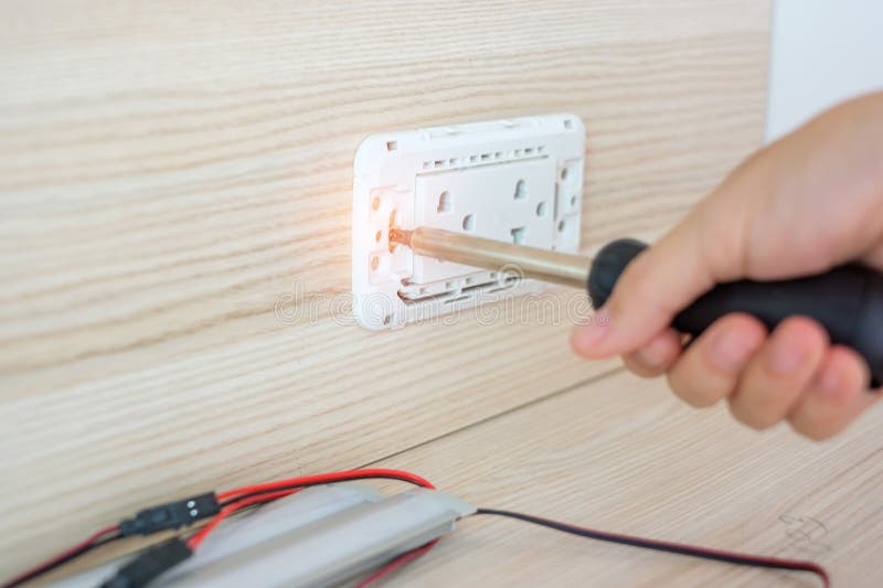 Man Hand Using Screwdriver Installing Wire Cables for Socket Plug