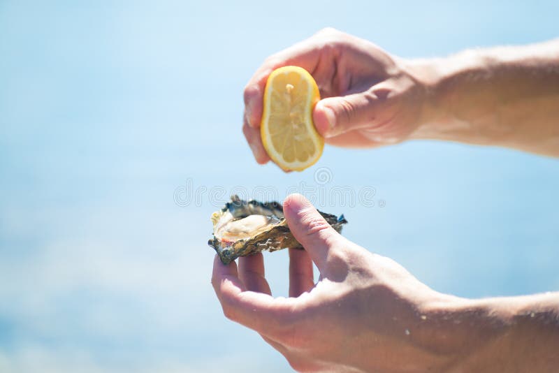 man-hands-holding-lemon-oyster-sunny-day-beach-hunting-strong-squeezing-delicate-meat-to-make-delicious-appetizer-59050493.jpg