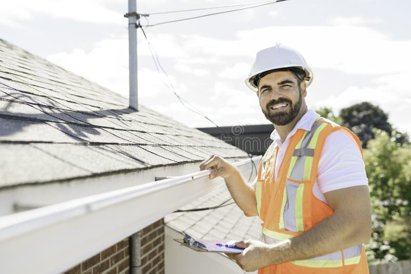 man in a hard hat, holding a clipboard, standing on the steps of an old rundown house.