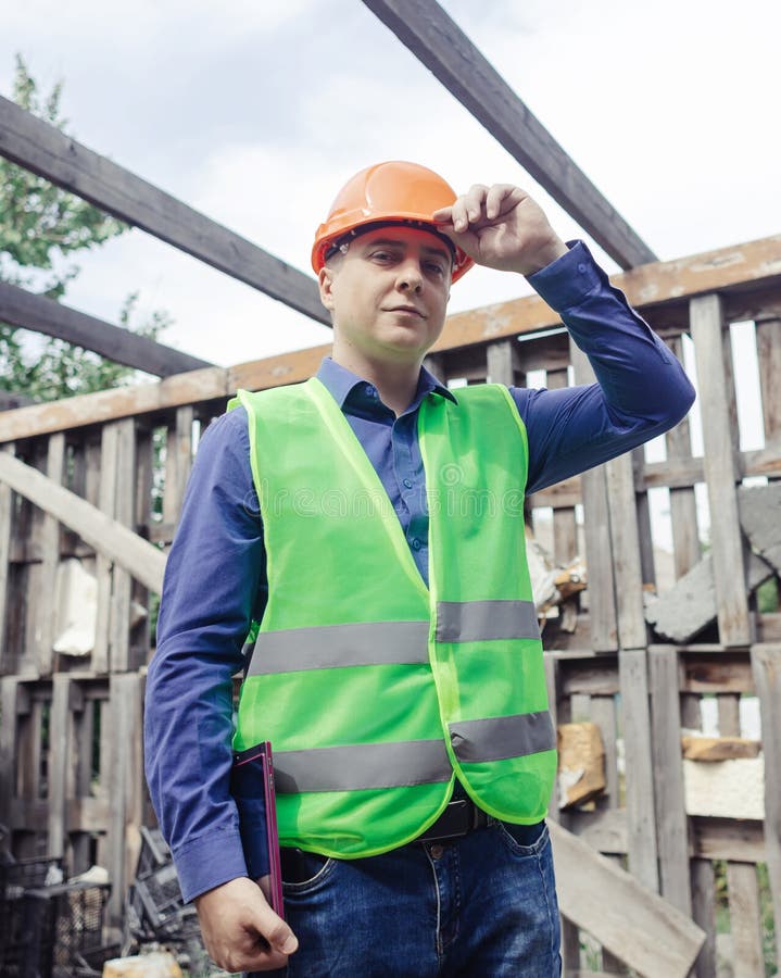 Building Inspector. Man in a Hard Hat and a Yellow Reflective Vest