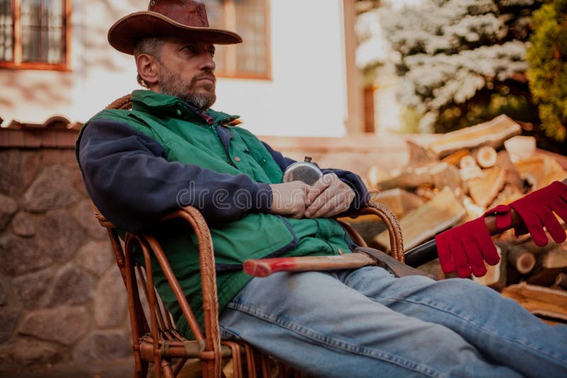 Man in hat sits in chair stock image
