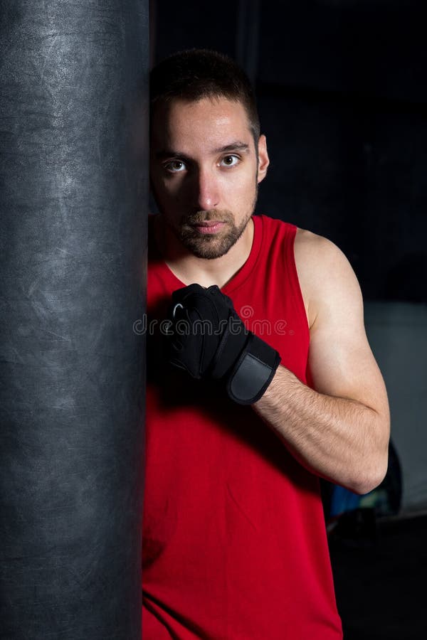 Man Punching a Boxing Bag stock image. Image of fitness 195096799