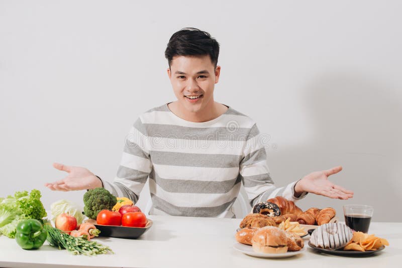 Man having hard choice between healthy and unhealthy food royalty free stock images Man having hard choice between healthy and unhealthy food royalty free stock images