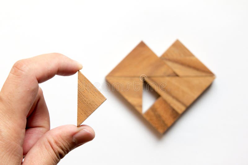 Man held piece of tangram puzzle to fulfill the heart shape on white background & x28;Concept of love& x29;