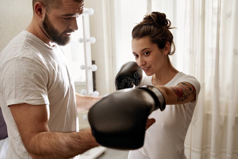 Man Helping To His Wife Wearing Gloves To Learn How To Do Box image