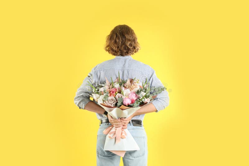 Man hiding beautiful flower bouquet behind his back