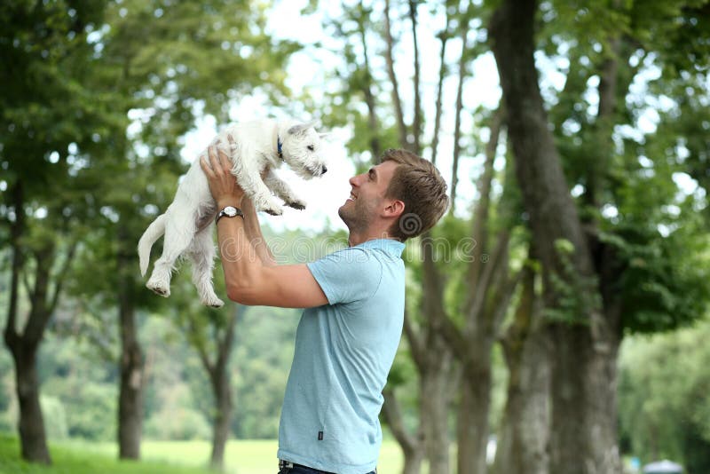 Young Man and Dog Playing Outdoor at Nature. Labrador or Golden