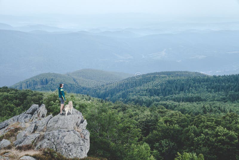 Man with his dog at the top of a mountain having a beautiful view stock photos Man with his dog at the top of a mountain having a beautiful view stock photos