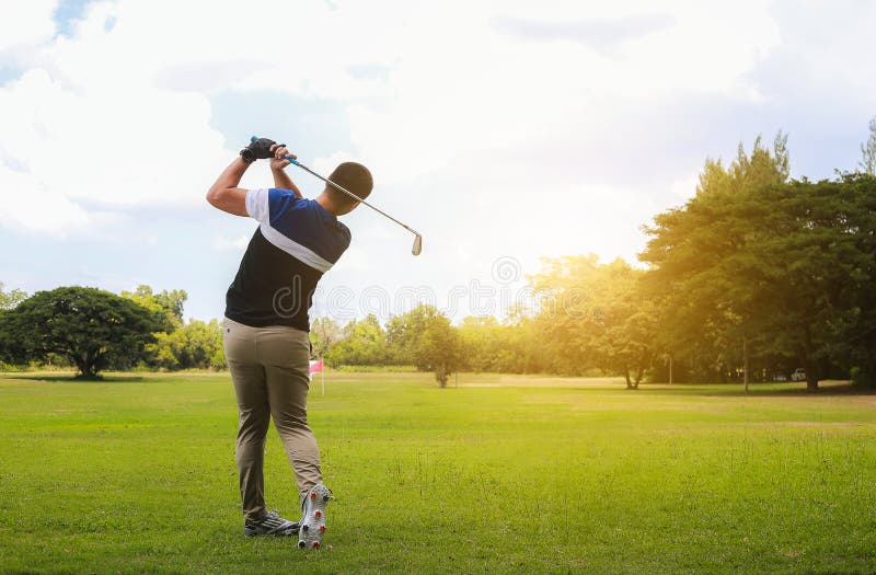 Man hitting golf shot with club on course while summer in the sun. royalty free stock image Man hitting golf shot with club on course while summer in the sun. royalty free stock image