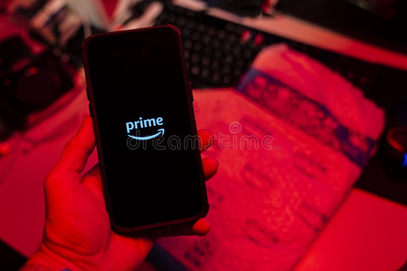 Man holding an Apple iPhone 14 Pro Max smartphone with Amazon Prime Video app on the screen Office environment. royalty free stock photos
