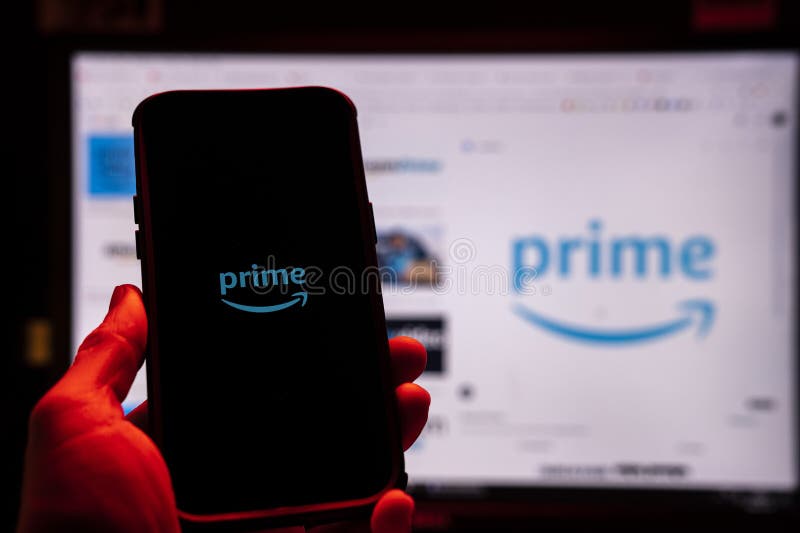 Man holding an Apple iPhone 14 Pro Max smartphone with Amazon Prime Video app on the screen Office environment. royalty free stock image