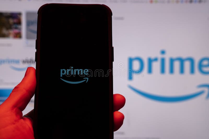 Man holding an Apple iPhone 14 Pro Max smartphone with Amazon Prime Video app on the screen Office environment. royalty free stock photo