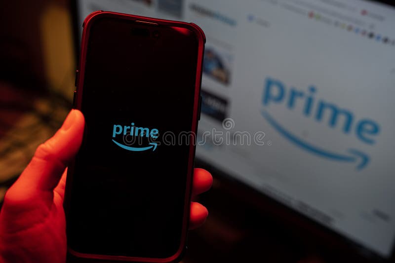Man holding an Apple iPhone 14 Pro Max smartphone with Amazon Prime Video app on the screen Office environment. stock photography