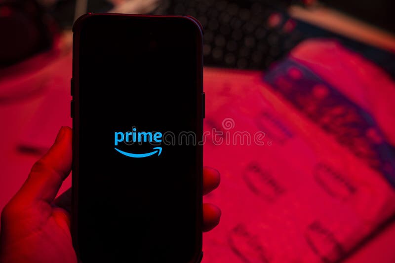 Man holding an Apple iPhone 14 Pro Max smartphone with Amazon Prime Video app on the screen Office environment. royalty free stock image
