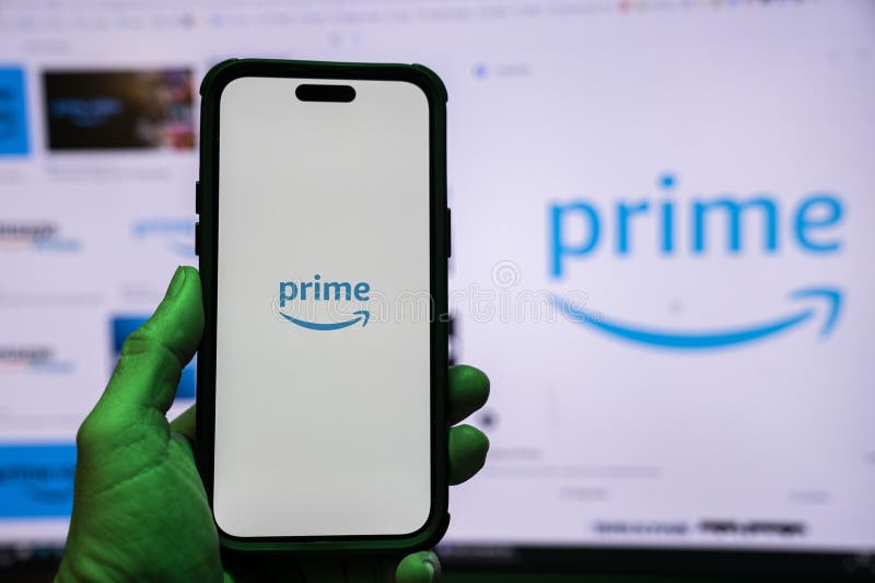 Man holding an Apple iPhone 14 Pro Max smartphone with Amazon Prime Video app on the screen Office environment. stock photos