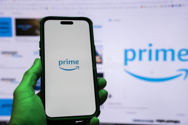 Man holding an Apple iPhone 14 Pro Max smartphone with Amazon Prime Video app on the screen Office environment. royalty free stock images