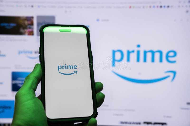 Man holding an Apple iPhone 14 Pro Max smartphone with Amazon Prime Video app on the screen Office environment. royalty free stock images