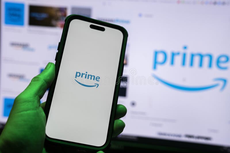 Man holding an Apple iPhone 14 Pro Max smartphone with Amazon Prime Video app on the screen Office environment. royalty free stock photo