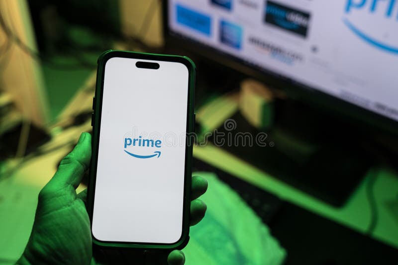 Man holding an Apple iPhone 14 Pro Max smartphone with Amazon Prime Video app on the screen Office environment. royalty free stock photos