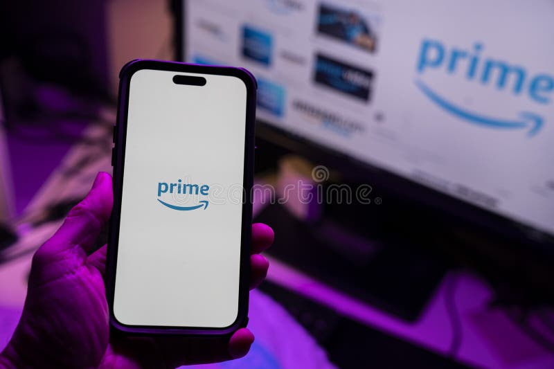Man holding an Apple iPhone 14 Pro Max smartphone with Amazon Prime Video app on the screen Office environment. stock photography