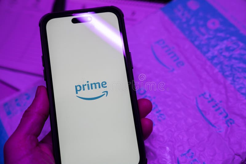 Man holding an Apple iPhone 14 Pro Max smartphone with Amazon Prime Video app on the screen Office environment. royalty free stock image