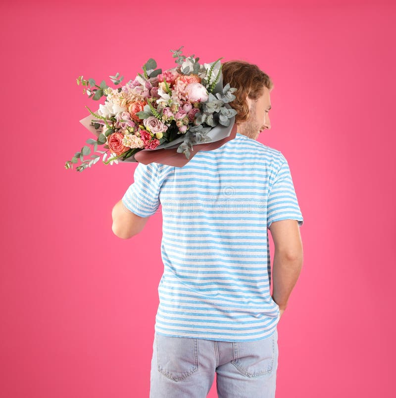 Man holding beautiful flower  on pink background