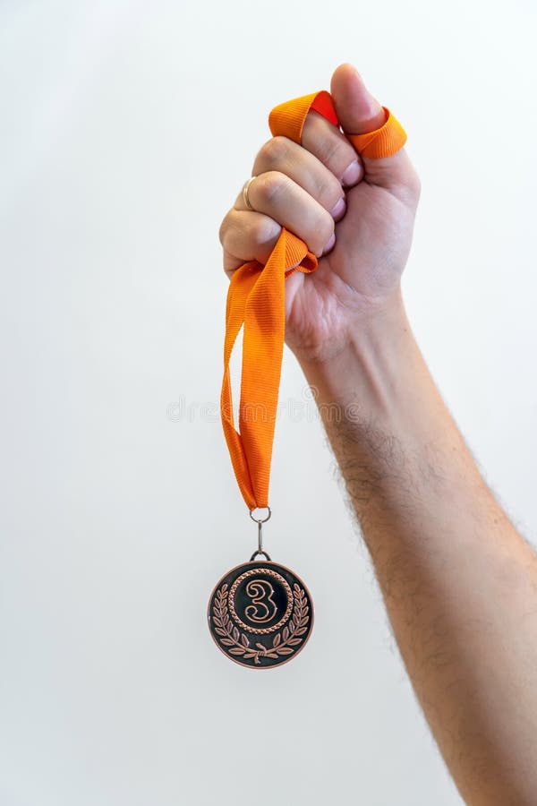 Man holding bronze medal on white background