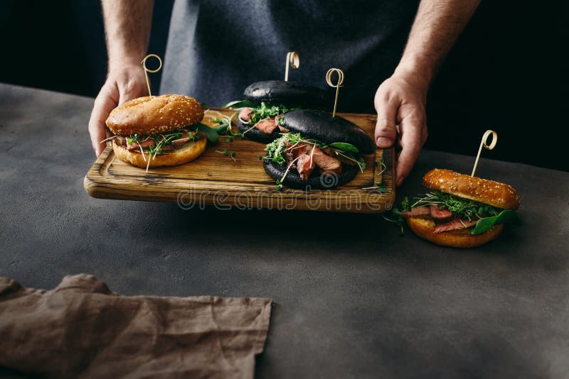 Man holding set burger beef medium rare spinach sauce