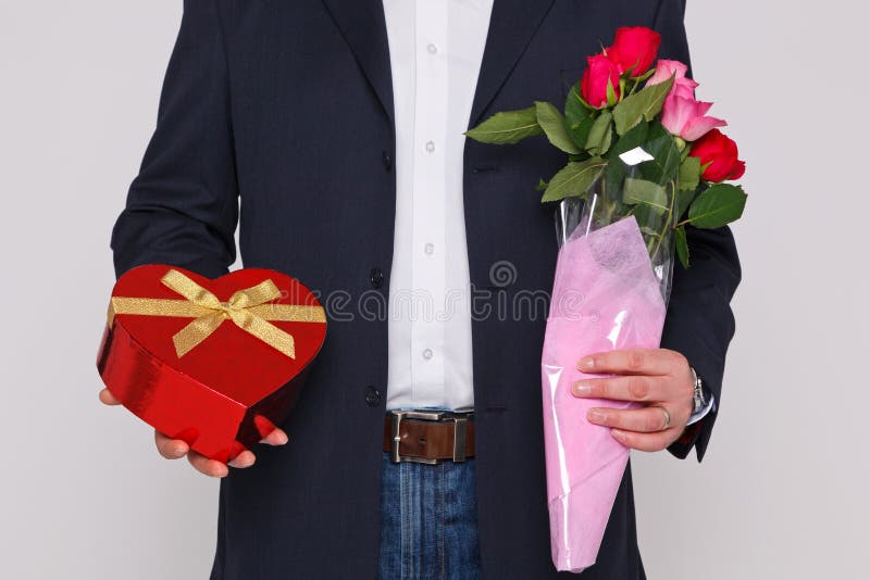 Man holding flowers and a box of chocolates stock photography Man holding flowers and a box of chocolates stock photography