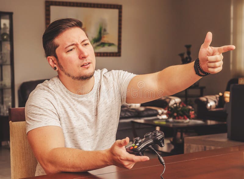 Man holding a game control and pointing finger like a gun stock photography Man holding a game control and pointing finger like a gun stock photography