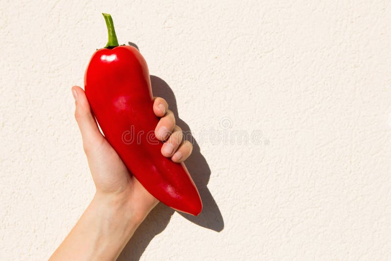 The Man is Holding a Large Red Pepper in His Hand. Stock Photo Image