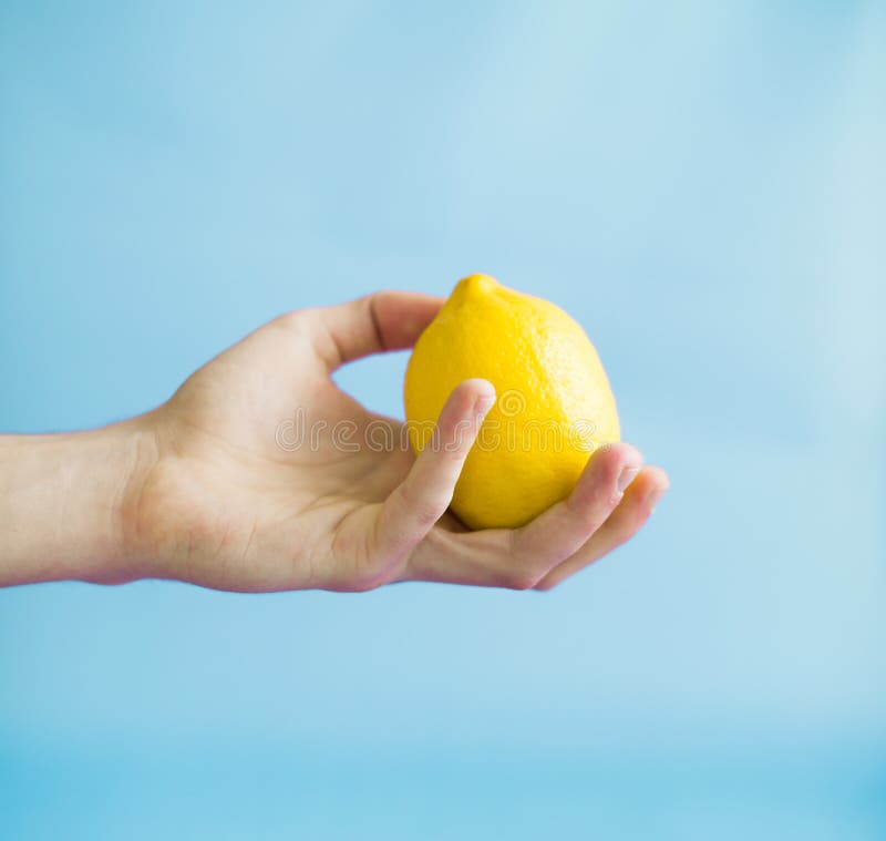 A Man Is Holding A Lemon Against A Blue Background Stock Image - Image ...