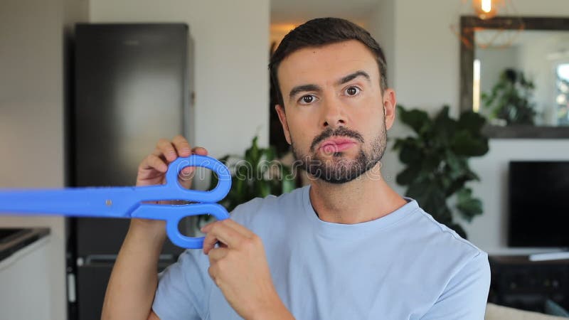 Man holding a pair of gigantic blue scissors stock video