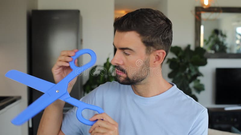 Man holding a pair of gigantic blue scissors stock footage