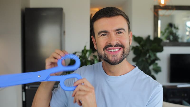 Man holding a pair of gigantic blue scissors stock video