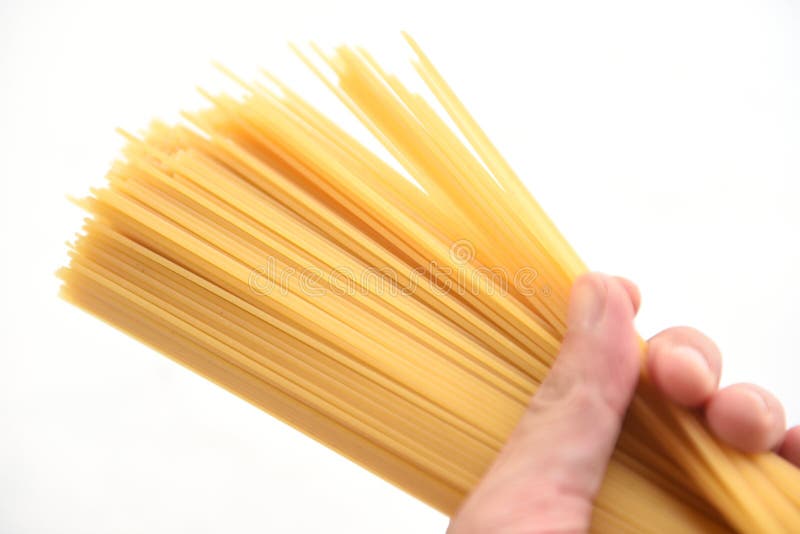 Man holding raw spaghetti italian pasta  uncooked spaghetti yellow long ready to cook in the restaurant italian food and menu