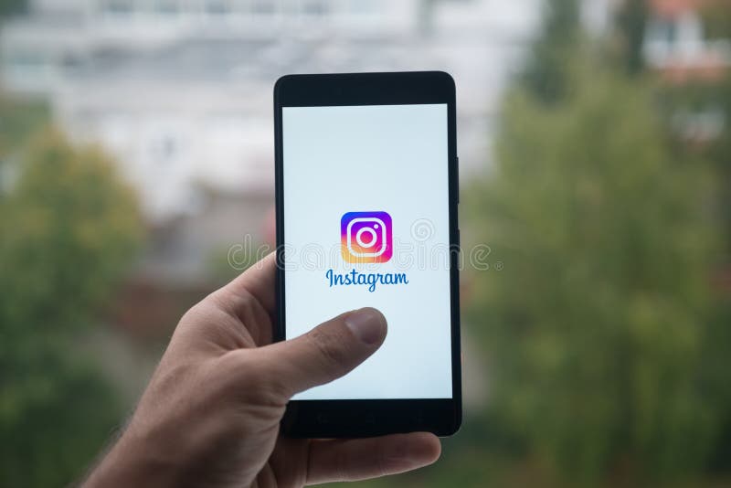London, United Kingdom, october 3, 2017: Man holding smartphone with Instagram logo with the finger on the screen. London, United Kingdom, october 3, 2017: Man holding smartphone with Instagram logo with the finger on the screen