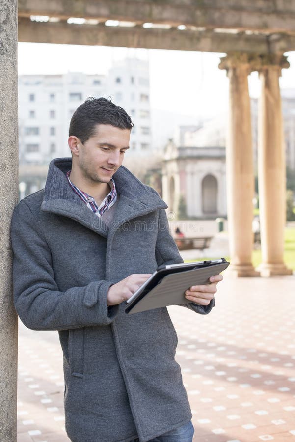 Man holding tablet computer in the park.