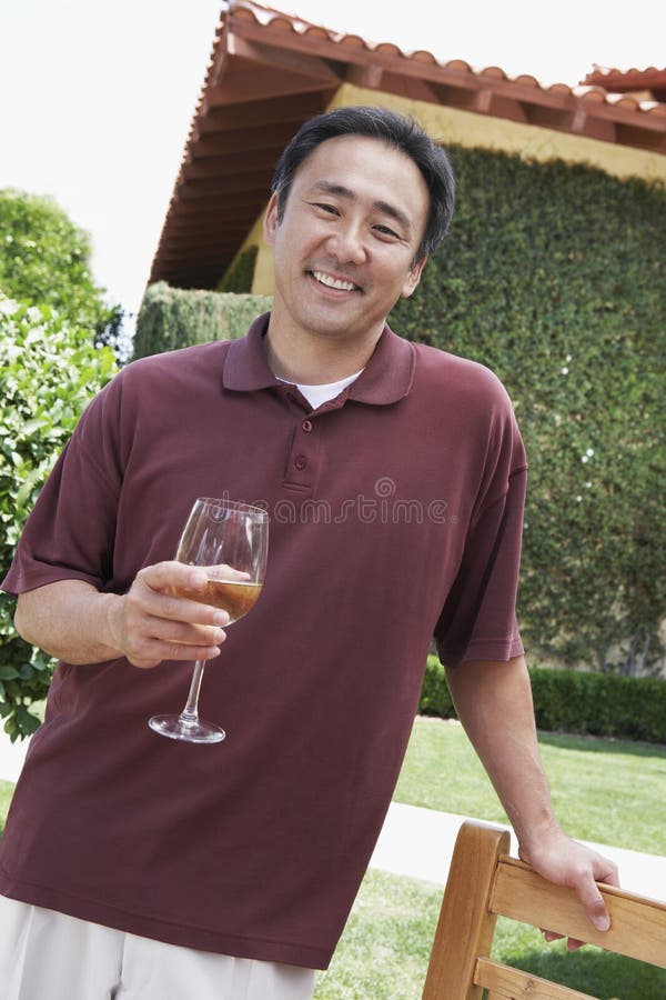 Man Holding Wineglass In Garden stock image Man Holding Wineglass In Garden stock image