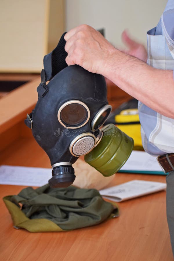A man holds a gas mask. Gas mask GP-7 close-up. Civil Defense Studies stock photo A man holds a gas mask. Gas mask GP-7 close-up. Civil Defense Studies stock photo