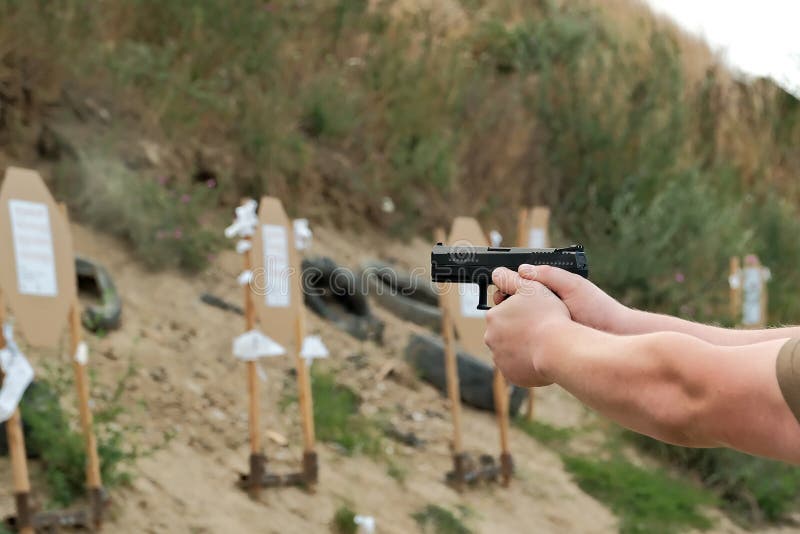 A Man Holds a Gun in His Hands. Pistol Shooting Exercises Stock Image