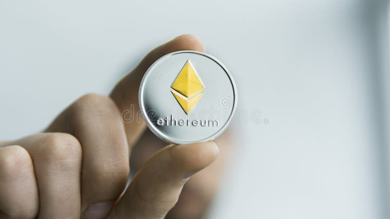Man holds in hands physical golden silver Ethereum. Cryptocurrency. Profit from mining crypto currencies. Miner with a royalty free stock photography Man holds in hands physical golden silver Ethereum. Cryptocurrency. Profit from mining crypto currencies. Miner with a royalty free stock photography