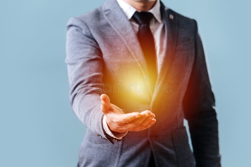 Man holds his hand in front of him showing off an object in the palm of his hand