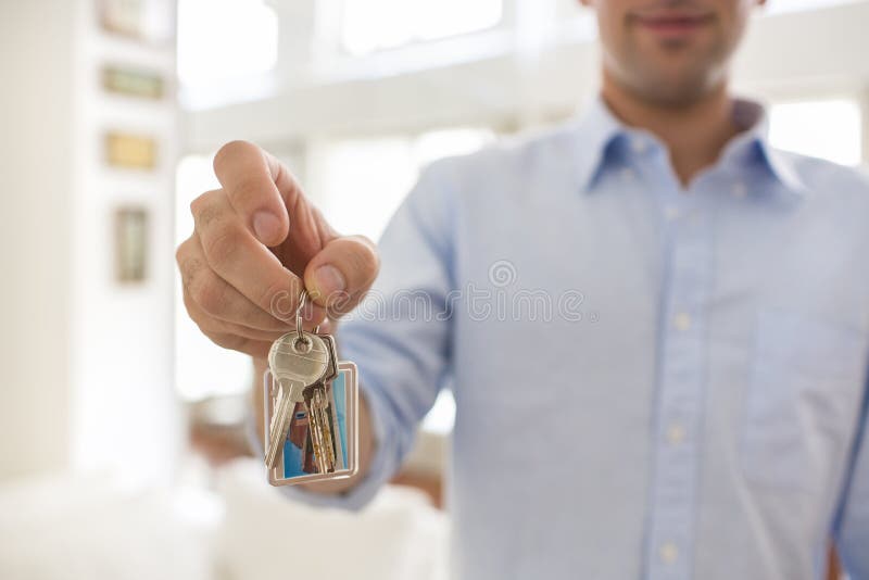 A man holds in his hand the keys of his house, indoor.