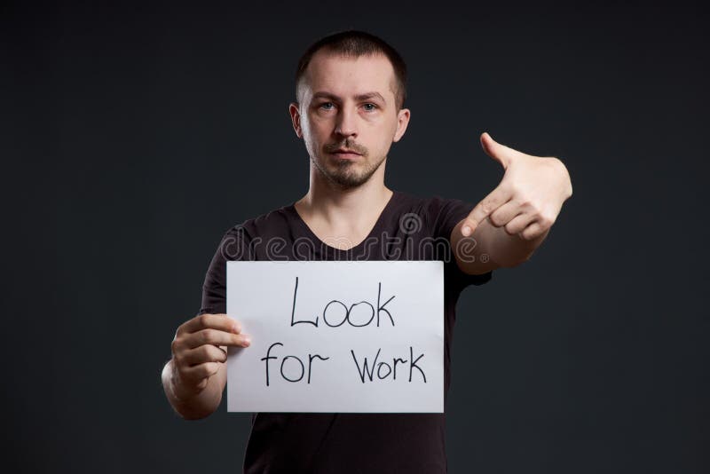 Man Holds A Sign With The Words Looking For Work Unemployment And