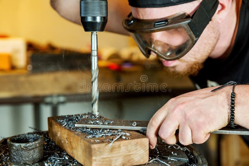Man i arbete på press för elektrisk drillborr royaltyfri fotografi Man i arbete på press för elektrisk drillborr royaltyfri fotografi
