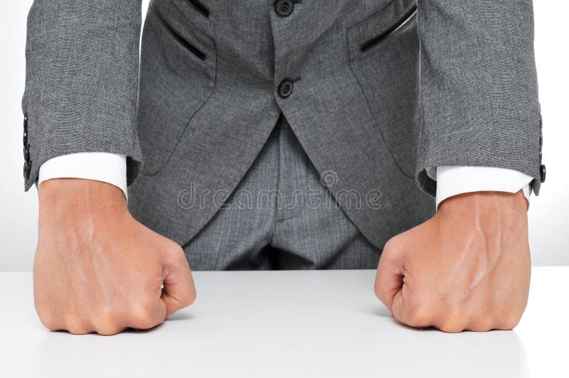 Man in suit withs his fists on the desk. Man in suit withs his fists on the desk